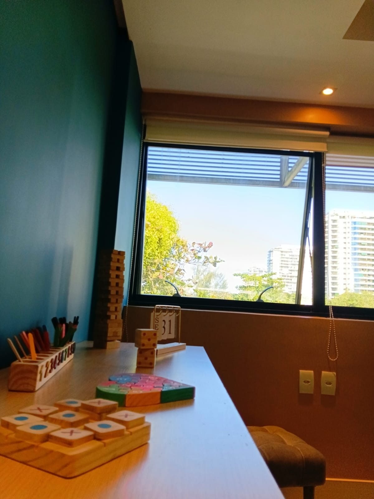 Mesa com materiais de estimulação cognitiva em madeira usados nas sessões da clínica.